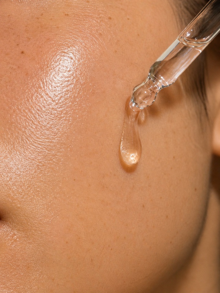 Close-up of radiant skin with a drop of Swissline skincare serum